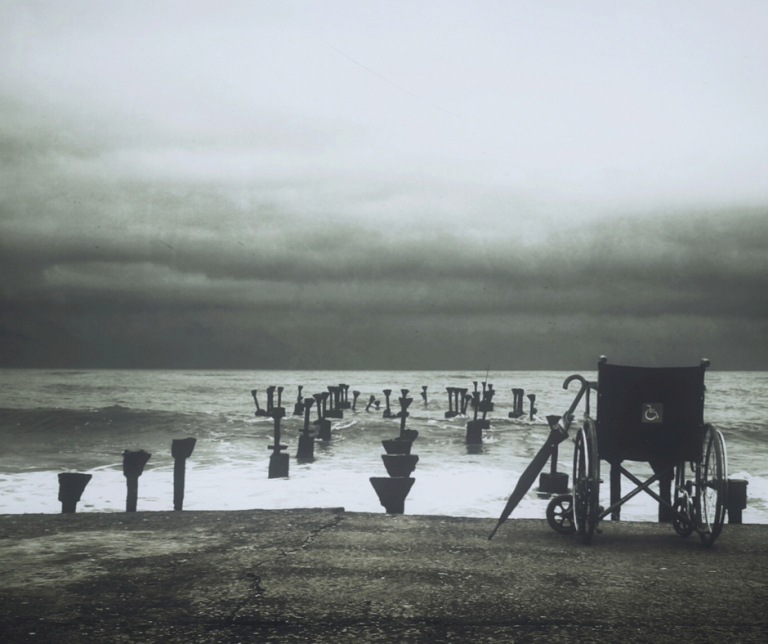 silla de ruedas frente al mar un dia de tormenta